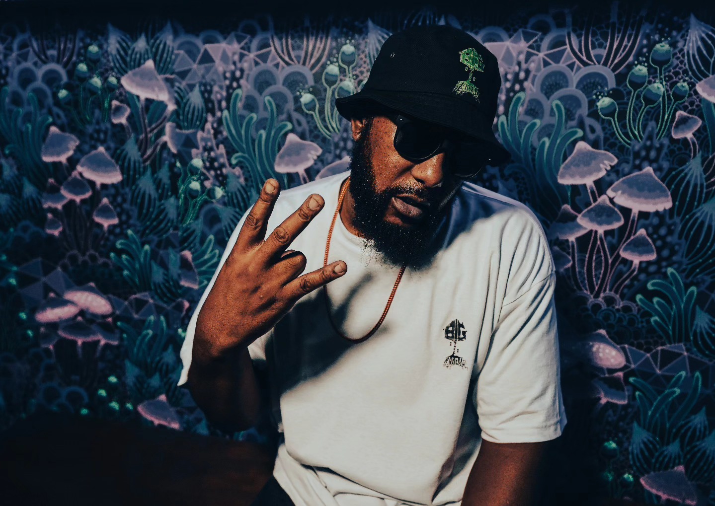 Big Tree #4Real throwing up a peace sign in a #4Real tee