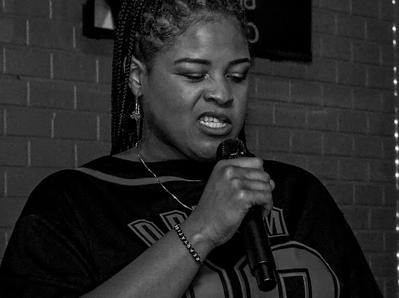 Dream close-up performance shot, microphone in hand against brick wall