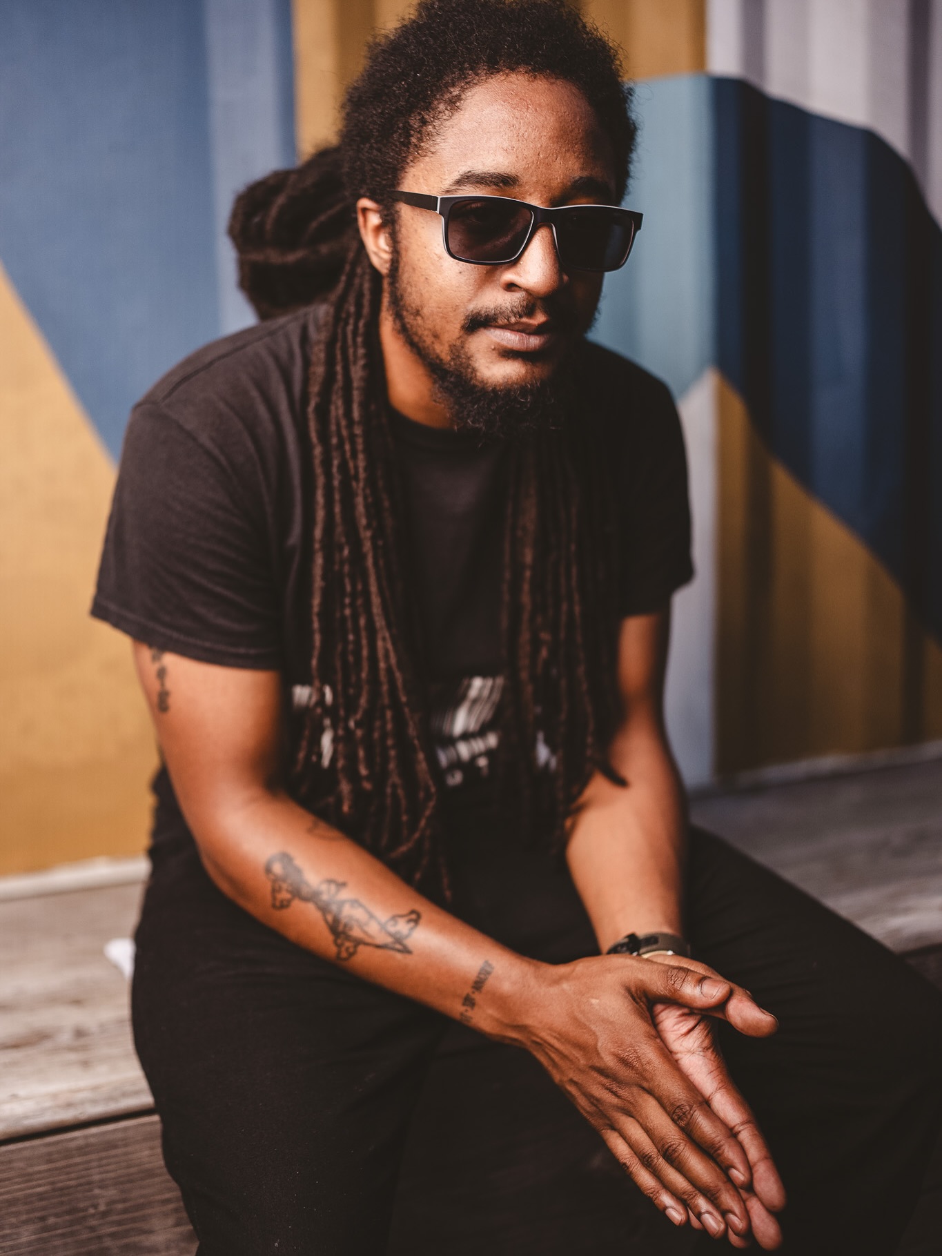 Mayb. L8ter seated portrait against a painted mural