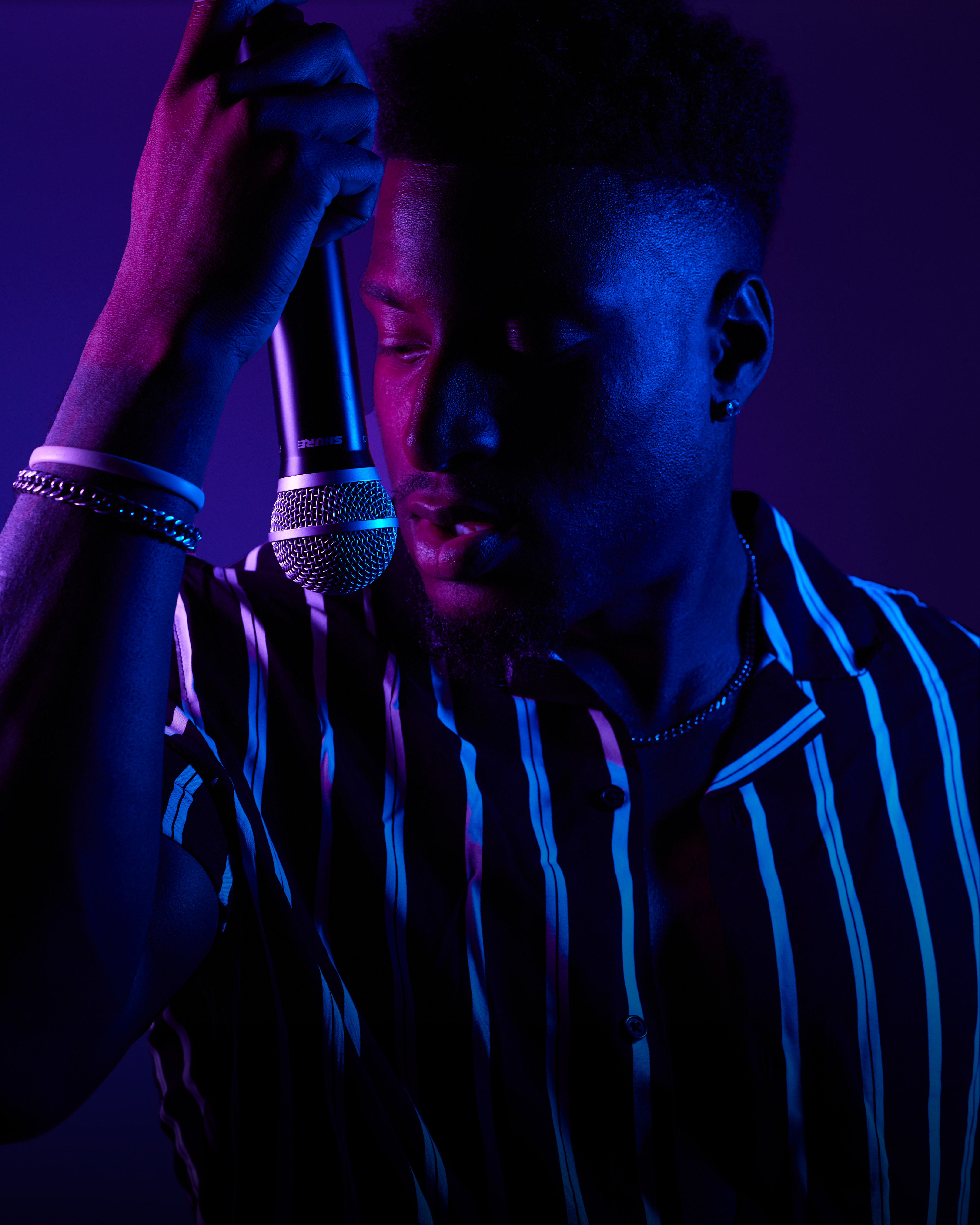 Tay No Tee studio portrait in striped shirt with microphone